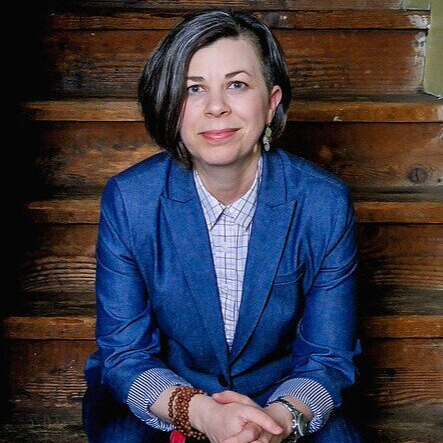 white women in blue suit jacket sitting on wooden stairs